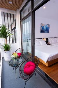 a bedroom with a bed and two chairs and a table at CELINA HOTEL Ninh Bình in Ninh Binh
