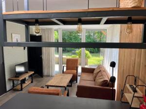 a living room with a couch and a table at De Zandzegge | 4 persons in Gasselte