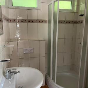 a white bathroom with a shower and a sink at Bungalow Zandzegge | 4 personen - Vakantiepark De Kremmer in Gasselte