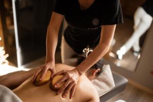 a woman getting a back massage from a man at Aktiv- und Wellnesshotel Traube- Post in Curon Venosta +91 photos
