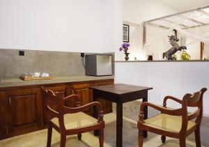 Manta Beach Resort & Ayurvedic Wellness Centre في غالي: مطبخ مع كرسيين وطاولة وكاونتر