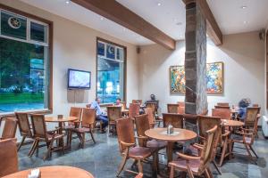 un restaurante con mesas y sillas y personas sentadas en mesas en Gran Hotel Isabel Riquelme, en Chillán 35 fotos más