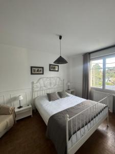 a bedroom with a white bed and a window at Les Villas de Puys - Dieppe in Dieppe