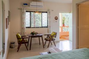 a room with a table and chairs and a bed at Baba Au Rhum Cafe & Stay in Morjim