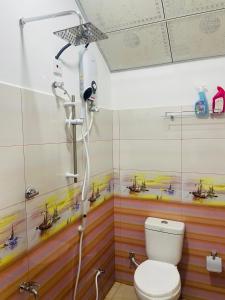 a bathroom with a toilet and a shower with boats on the wall at Ella Sky Cabana in Ella