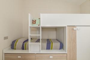 een wit stapelbed met daaronder een stapelbed bij Villetta Lu Lioni in San Teodoro