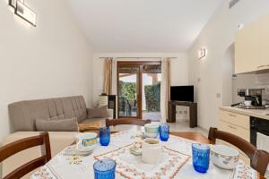 een keuken en woonkamer met een tafel en stoelen bij Villetta Lu Lioni in San Teodoro +13 foto's