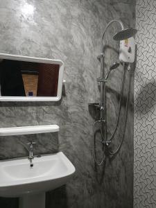 a bathroom with a sink and a shower with a shower at Lanta Baansuan Rimthan in Ko Bu Bu