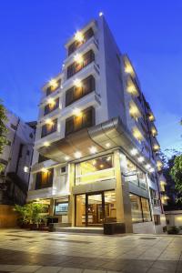 a large white building with lights on it at Hotel Accolade in Ahmedabad