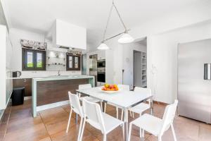 a kitchen and dining room with a white table and chairs at Villa Antinoti in Agía Aikateríni