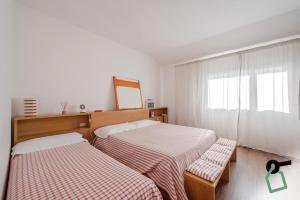 a bedroom with two beds and a mirror and a window at HOTIDAY Room Collection - Sarzana in Sarzana