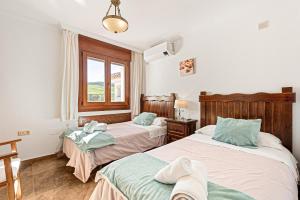 une chambre avec deux lits et une fenêtre dans l'établissement Villa Antequera, à Malaga 34 autres photos
