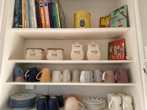 a shelf filled with cups and plates and books at Hus Hornsö in Blomstermåla