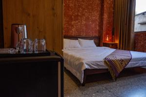 a bedroom with a bed and a table with glasses on it at Chamhouse - Long Thủy - Phú Yên in Long Thủy