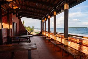 a row of benches in a restaurant overlooking the ocean at Chamhouse - Long Thủy - Phú Yên in Long Thủy