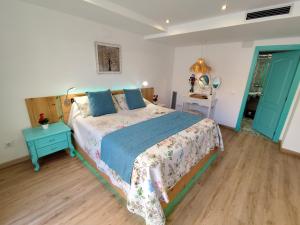 ein Schlafzimmer mit einem großen Bett und einem blauen Tisch in der Unterkunft Casas del Castillo Peñíscola-Intramuros Suites in Peñíscola