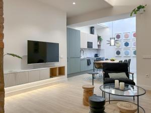 ein Wohnzimmer mit Fernseher und Tisch in der Unterkunft Apartment Gaudi in Vilanova i la Geltrú