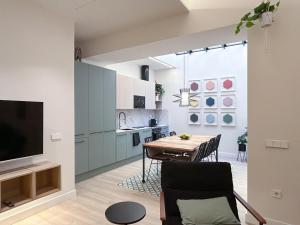 eine Küche und ein Esszimmer mit einem Tisch und einem TV in der Unterkunft Apartment Gaudi in Vilanova i la Geltrú