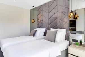 梅杜林Fly Room - S3 - MPolo的卧室设有两张白色的床和石墙