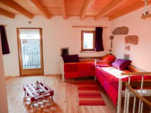 Una sala de estar con un sofá rojo y una mesa. en Casa delle Antiche Pietre, en Cannero Riviera