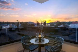 a table and chairs on a balcony with a sunset at Fly Room - S5 - MPolo in Medulin