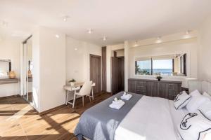 a bedroom with a large white bed and a table at Ayia Napa Seafront Ionion Villa H5 in Ayia Napa +67 photos