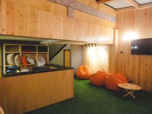 a room with orange bean bags and a television at Double Five in Bangkok