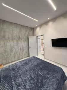 a bedroom with a large bed and a flat screen tv at Elias house in Tríkala
