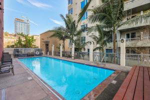 a swimming pool with a bench next to a building at Your Urban Oasis in the Heart of Little Italy in San Diego
