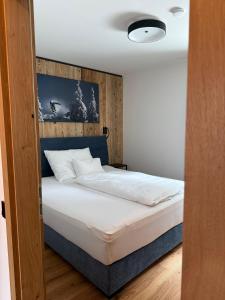 a bedroom with a bed with a wooden headboard at Chalet1500 Apartment Gerlitzen - Kärnten Card im Sommer inklusive! in Kanzelhöhe