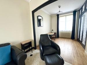 una sala de estar con un sofá y una silla en Grande Maison-5 min de Chambord-3 chambres-Loire à vélo 100 m- 10 min de Blois, en Saint-Claude-de-Diray
