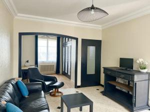 sala de estar con sofá de cuero negro y silla en Grande Maison-5 min de Chambord-3 chambres-Loire à vélo 100 m- 10 min de Blois, en Saint-Claude-de-Diray