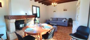 a living room with a table and a fireplace at La Petite Cassagne in Saint-Geniès