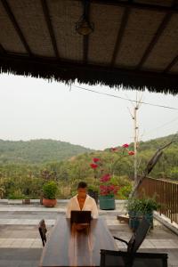 un hombre sentado en una mesa con un portátil en Lecolau Villa, en Phu Quoc 52 fotos más