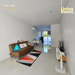 a living room with a brown couch and a living room at NEW! Tha-win home3 #10minLeegarden #minDimsumChabura in Sathani Hat Yai