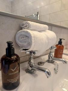 a bathroom sink with a towel and a bottle of soap at Five Star Luxury - Oxnead Hall in Burgh next Aylsham
