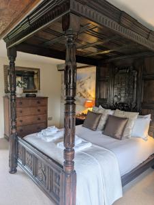 a bedroom with a large canopy bed with white sheets at Five Star Luxury - Oxnead Hall in Burgh next Aylsham