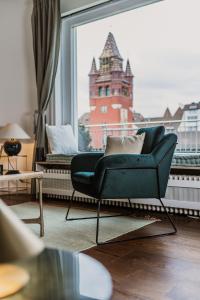 a living room with a chair and a large window at The Penthouse Basel in Basel
