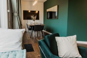 a living room with a table and a green wall at The Penthouse Basel in Basel