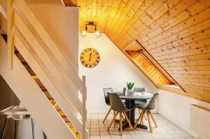 una sala da pranzo con un tavolo e un orologio a parete di KleineMuschelbude a Dornum