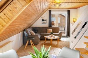 un soggiorno con divano e scale di KleineMuschelbude a Dornum