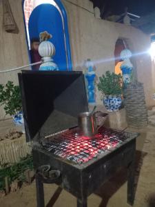 a table with a pot in a room with vases at Dar alibaba in Douz