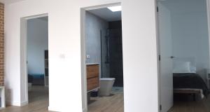 Un dormitorio con paredes blancas y un baño. en La Terraza del Faro, en Mazo 35 fotos más