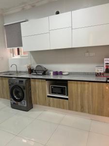 een keuken met witte kasten en een vaatwasser bij Luxurious 2 bedroom apartment Ikoyi in Ikoyi