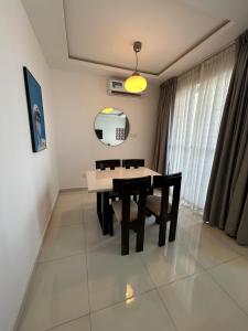 een eetkamer met een tafel, stoelen en een spiegel bij Luxurious 2 bedroom apartment Ikoyi in Ikoyi +4 foto's