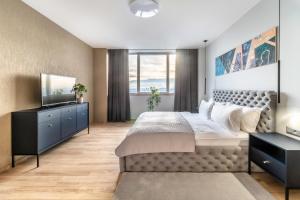 a bedroom with a large bed and a television at Holiday Inn Zilina by IHG in Žilina