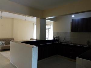 una cocina con una gran encimera negra en una habitación en SHE Homes, en Mombasa