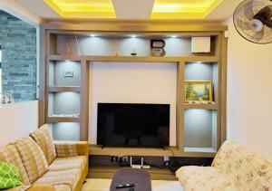 a living room with a couch and a flat screen tv at Modern luxury 4-Bedroom Villa with Private Pool, BBQ flic en flac in Flic-en-Flac