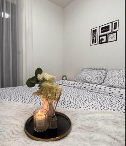 a tray with a candle and flowers on a bed at Luxe Central Living Apartment in Debrecen