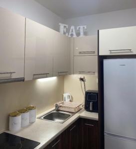 a kitchen with a sink and a refrigerator at Luxe Central Living Apartment in Debrecen
